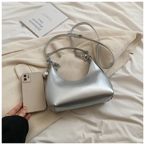 Gros plan d'un sac hobo argenté effet miroir avec une breloque sphérique élégante