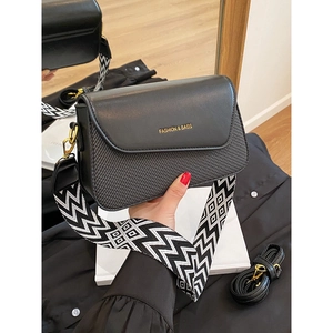 Chic black leather square bag with woven texture and patterned wide shoulder strap