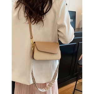 Chic women's shoulder bag with leather and woven texture mix shown on model