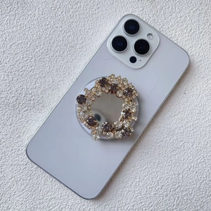 Detail of expandable phone grip with sparkling purple and clear rhinestones on white phone