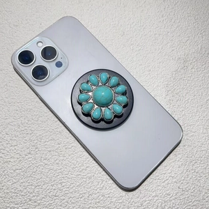 Close-up of a vintage turquoise stone phone socket grip mounted on a white device