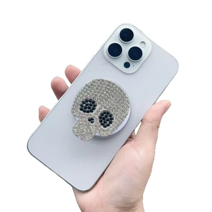 Sparkling crystal skull magnetic phone socket holder mounted on purple mobile phone