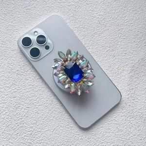 Detail shot of a luxury diamond phone socket with a large blue gem and sparkling rhinestones