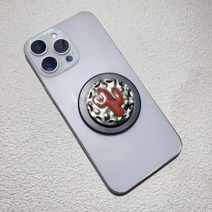 Detail of vintage electroplated phone grip with a red cactus design on a metal base