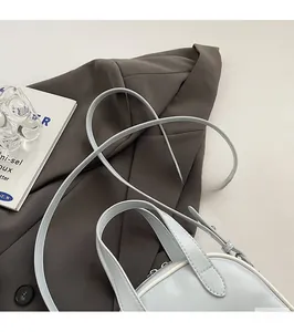 Détail du sac à main bleu clair avec bordures blanches contrastées et bandoulière élégante