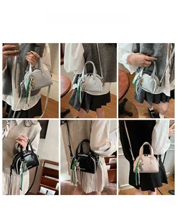 Sac Boston porté en bandoulière, disponible en bleu, rose et noir avec breloque d'ours