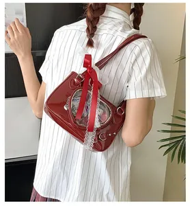 Detail of wine red patent leather ita bag featuring heart window and lace trim