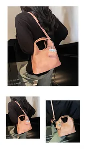Macro view of peach-pink faux leather tote bag showing fine texture and matching pouch