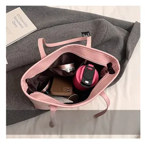 Top view showing large interior capacity of pink tote bag with phone and cosmetics