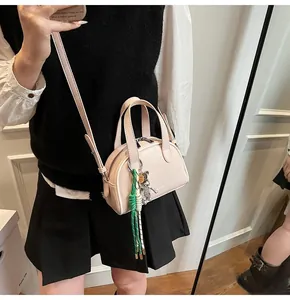 Détail du mini sac Boston rose avec breloque ours et corde tressée sur la bandoulière