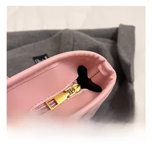 Close-up of premium golden metal zipper on a pink leather tote bag for women