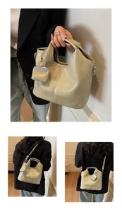Detail view of beige matte PU leather tote with vertical stitching and mini pouch charm