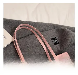 Detail view of pink tote bag showing stitched leather handles and cute cartoon prints