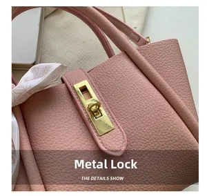 Gros plan du sac en cuir rose avec fermoir doré rotatif et détail de foulard en soie