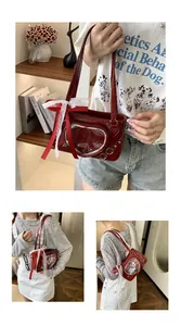 Detail view of red faux leather ita bag featuring heart window and lace bow accents
