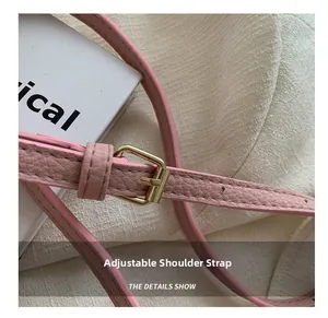 Détail de la bandoulière en cuir rose grainé avec boucle en métal doré réglable