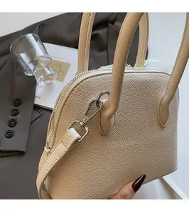 Détail d'un sac coquillage beige en cuir grainé avec finitions argentées élégantes