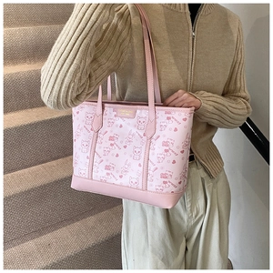 Detail view of the pink tote bag featuring cartoon animal patterns and a golden metal logo