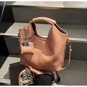 Detail of apricot pink tote bag featuring lychee texture leather and adjustable strap