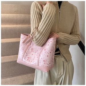 Close-up of pink tote bag with cartoon patterns and letters on a casual staircase