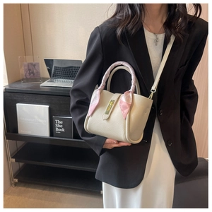 Détail du sac seau blanc cassé avec cuir grainé et foulard en soie rose décoratif