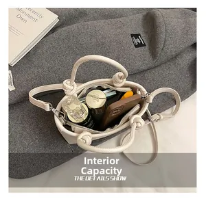 Detail view of the beige bucket bag interior showing capacity for phone and wallet