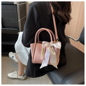 Sac seau en cuir rose grainé avec foulard en soie et détails métalliques dorés élégants