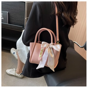 Sac seau rose en cuir grainé avec foulard décoratif en soie et fermoir rotatif doré