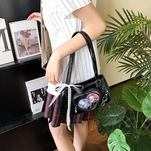 Detail of black heart-shaped ita bag with clear window, anime badges and lace bow