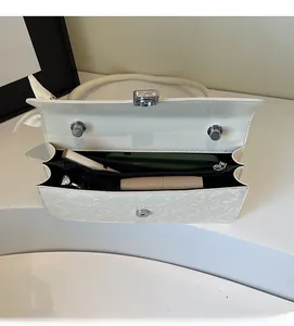 Internal view of a white quilted handbag showing spacious compartments with daily essentials