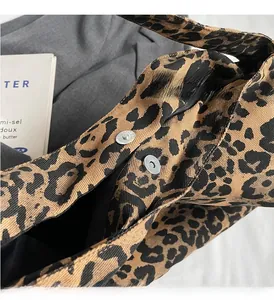 Detail of silver magnetic buckle closure on leopard print canvas tote bag with black lining