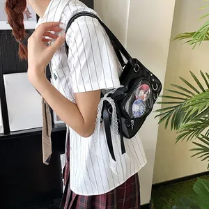 Detail of heart-shaped black leather ita bag featuring a clear window and lace trim