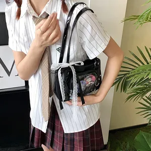 Detail of a black glossy ita bag with heart window and lace bow, worn with JK uniform