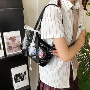 Close-up of black glossy Ita bag featuring lace bows and transparent window for badges