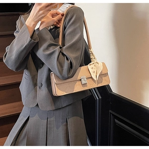 Detailed view of apricot square bag with geometric embossing and floral silk scarf detail