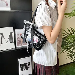 Detail of black ita bag featuring a transparent heart window and lace bow decoration