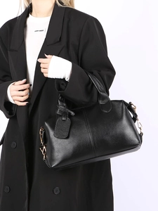 Close-up of black lychee grain leather boston bag with gold chain strap and detail stitching