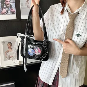 Detail of heart-shaped transparent window on a black patent leather ita bag with lace bow