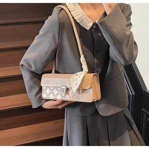 Detail of beige square bag with geometric texture, silver buckle and floral silk scarf