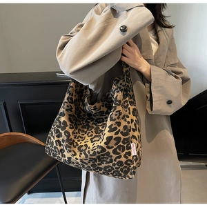 Detail of leopard print tote bag with Dougu Bag logo tag shown on person side view