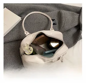 Detail showing the large interior capacity of this beige pillow bag with personal items