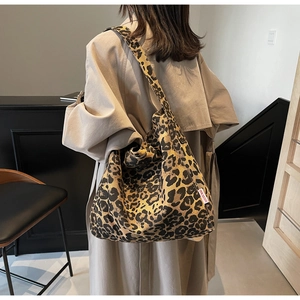 Detailed back view of a large leopard print tote bag featuring a branded side woven label