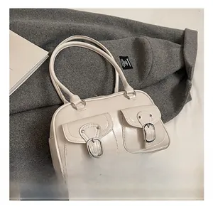 Detailed macro view of the cream-white faux leather tote bag with stylish buckle front pockets