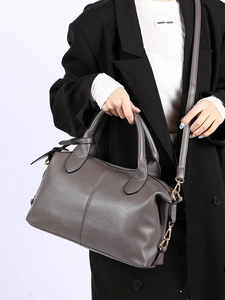 Detail of dark gray pebbled leather Boston bag with dual handles and removable strap