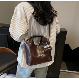 Detail of dark brown vintage oil wax leather tote bag worn by model in city style