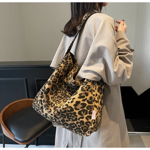 Close-up of leopard print tote bag fabric and white Dougu Bag woven side label