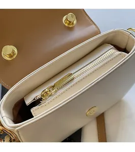 Close-up of beige crossbody bag interior featuring zipper pocket and magnetic buckle