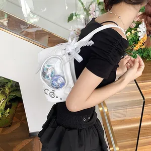 White Ita bag detail with transparent window, lace trim and heart charm on stairs