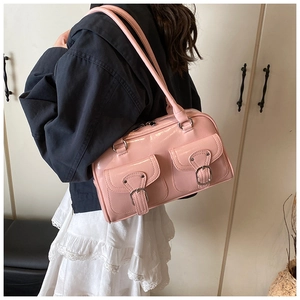 Detail of pink glossy patent leather tote bag with silver buckles shown on shoulder