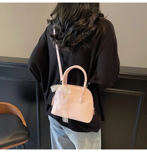 Sac rose en forme de coquille avec texture grainée et nœud en dentelle sur mannequin
